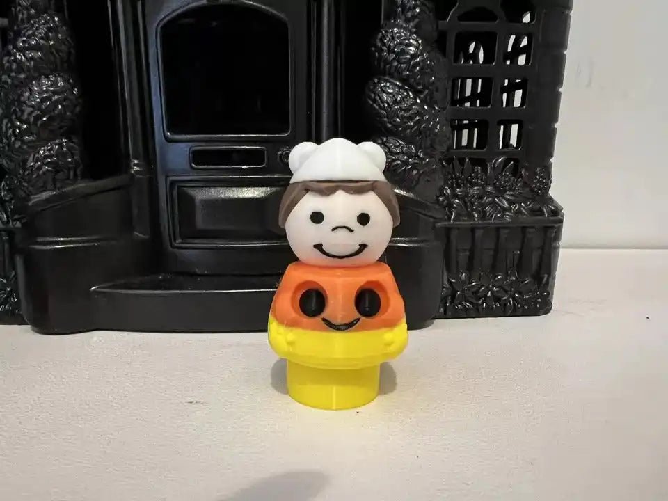 A custom Fisher-Price Little People-style Candy Corn Girl figure stands in front of a dark toy house.