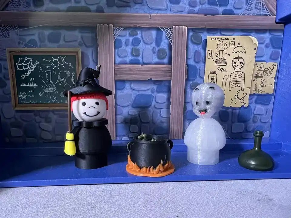 A custom Fisher-Price Little People-style red hair witch with a broom, ghost figure, and cauldron are displayed on a shelf.