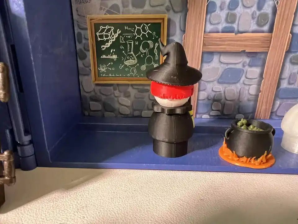 Halloween witch figurine with black hat and broom, red trim at face
