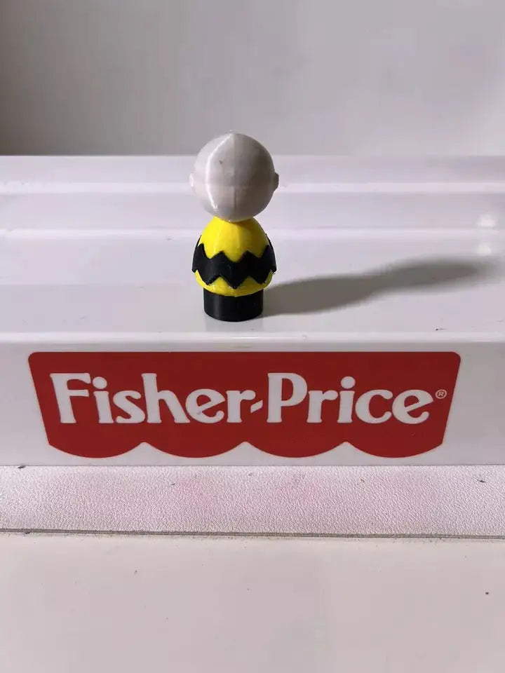 Small character figure seen from the back, gray head and yellow black zigzag outfit
