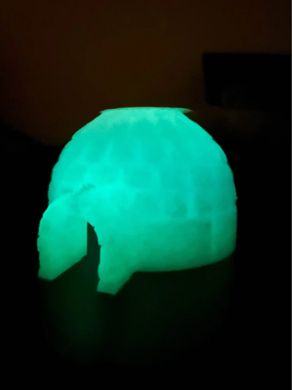 A glow-in-the-dark, transparent ice igloo custom-designed for Fisher-Price Little People figures, viewed in a dim setting.