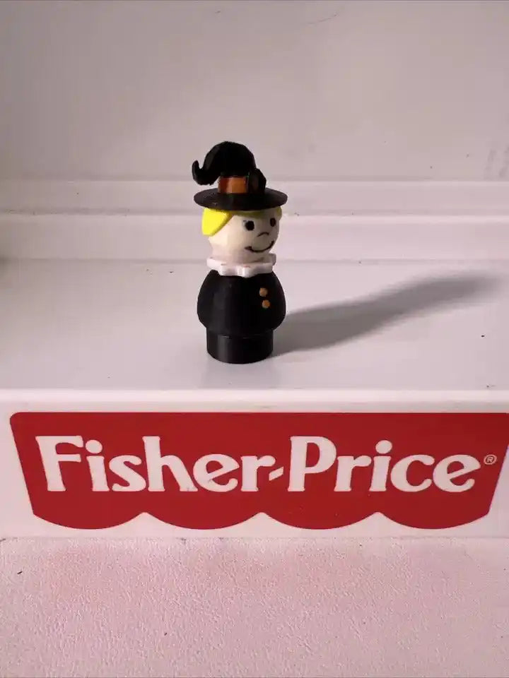 Halloween witch figurine with black hat and dress, white face and yellow collar detail.