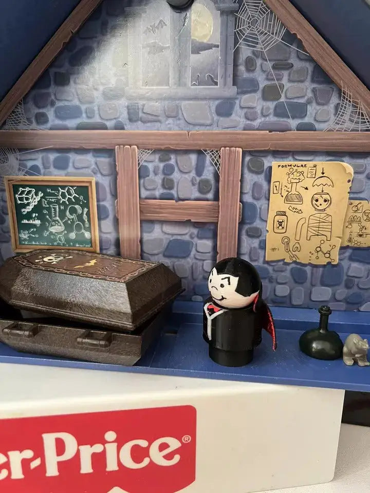 Dracula-style vampire figure in black with red cape, white face, standing on base.