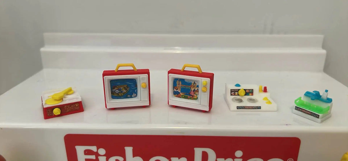 Miniature retro toy playset with two red TVs, record player, and small appliance pieces