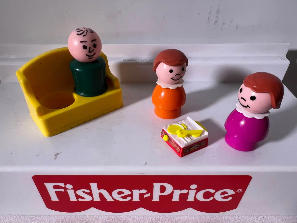 Three custom Fisher-Price Little People figures, including one on a yellow couch, and a miniature xylophone toy.