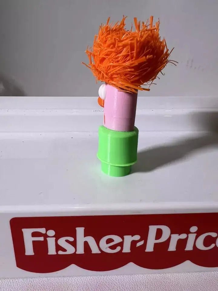 Muppets Beaker character figure with orange hair, orange nose, and pink torso