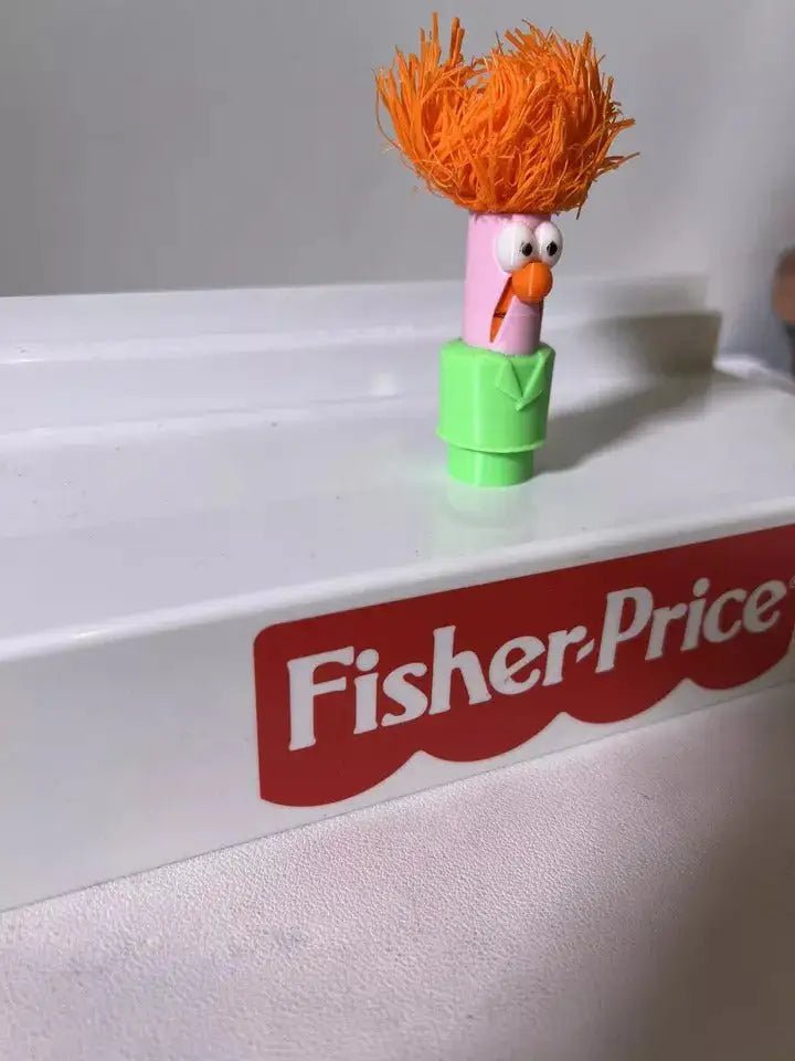 Muppets Beaker doll with orange hair, white eyes, orange nose, and green body