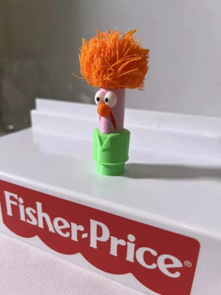 Muppets Beaker figurine with orange hair and orange nose on a green base