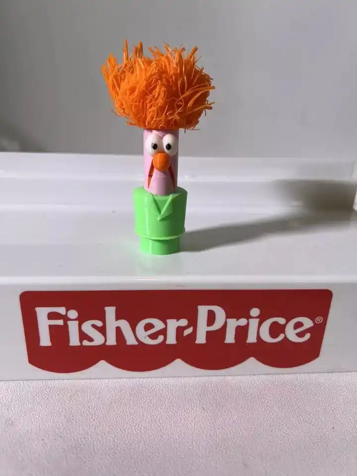 Orange-haired Muppets Beaker figurine with green body and pink neckpiece