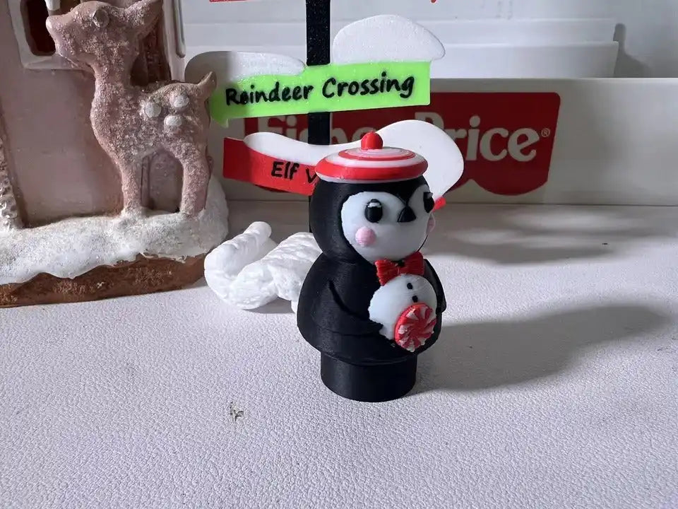 Peppermint penguin holiday figurine holding red-and-white peppermint candy