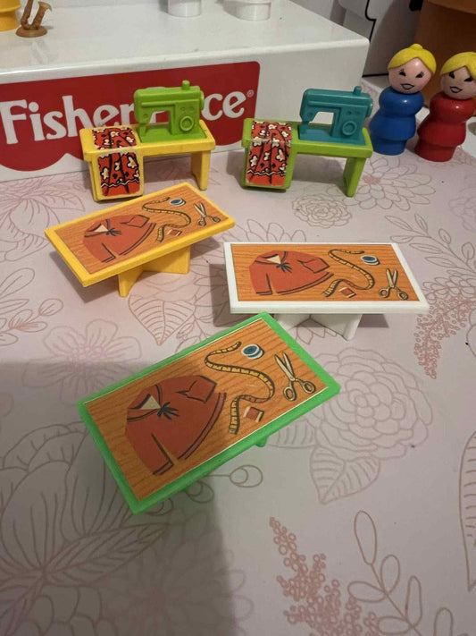 Toy sewing table playset with green and yellow bases, machines, and three fabric pattern cards
