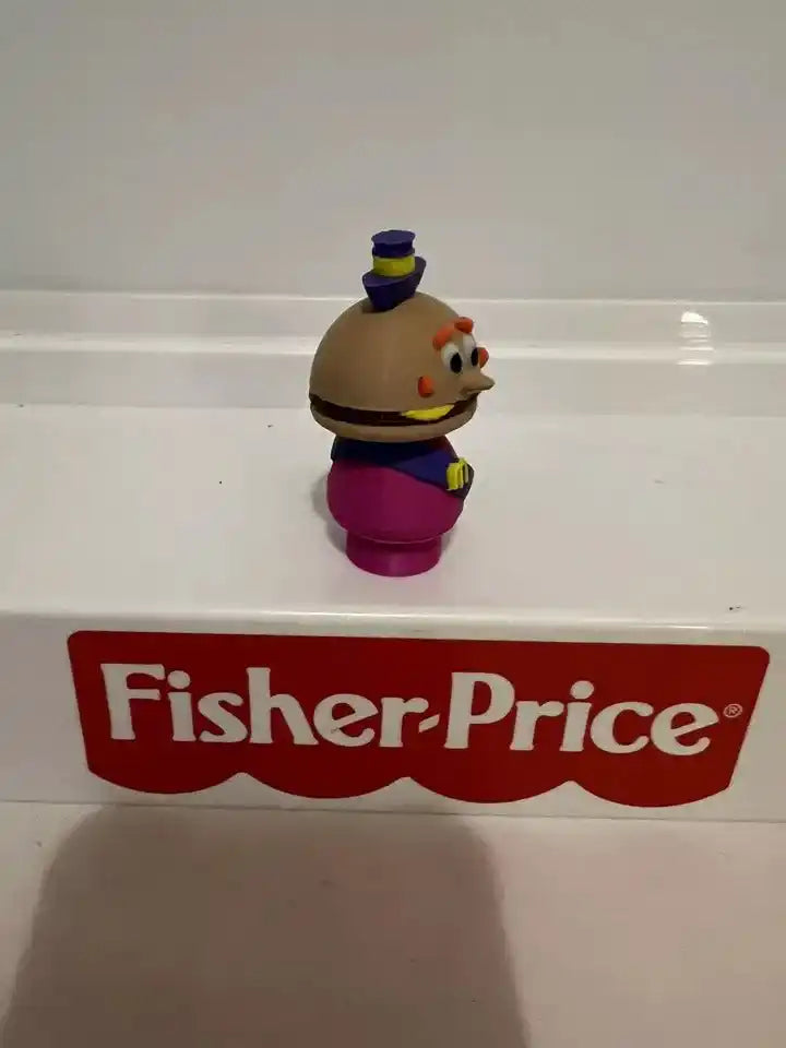 Cheese-headed toy mayor figurine, angled view, brown head, magenta suit, blue hat