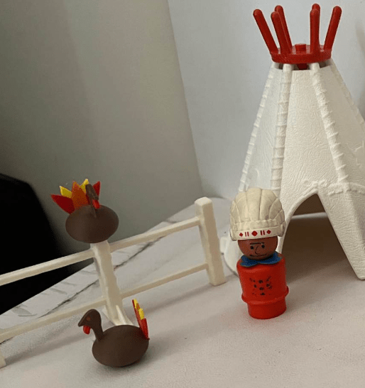 Turkey figurine with brown body and red comb on a small white base