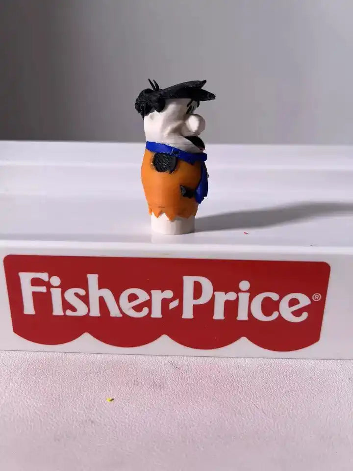 Fred Flintstone toy figure in orange and blue tunic, black hair