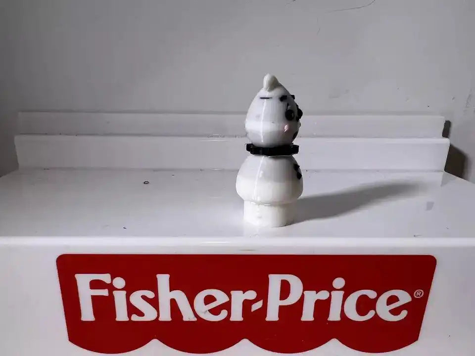 White ghost figurine with black dot eyes and small black collar
