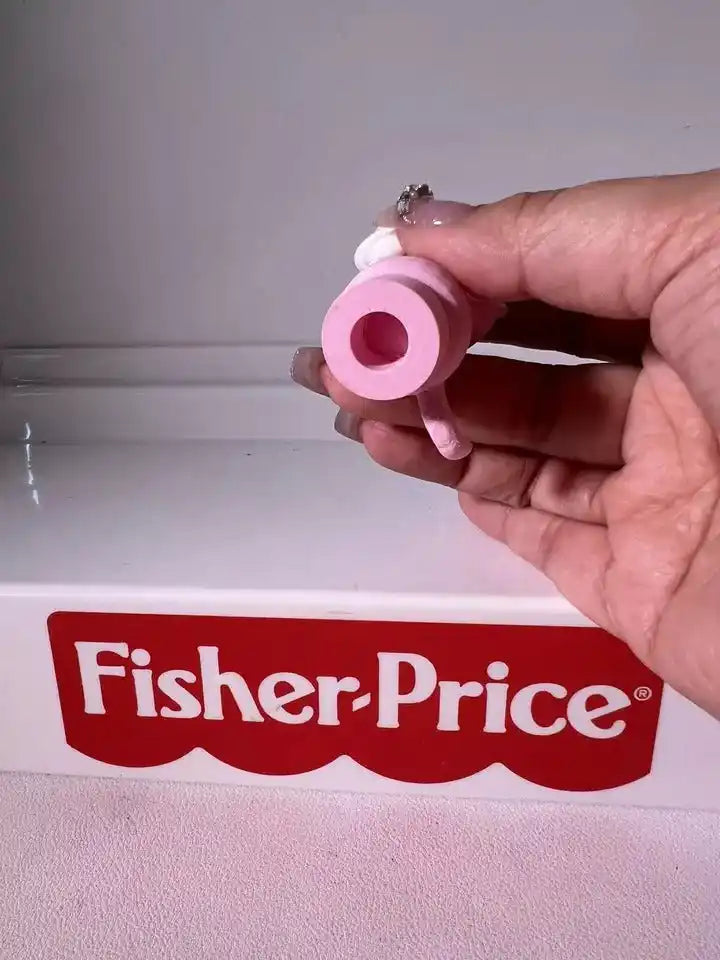 Pink panther toy figurine base with round hole, held in hand
