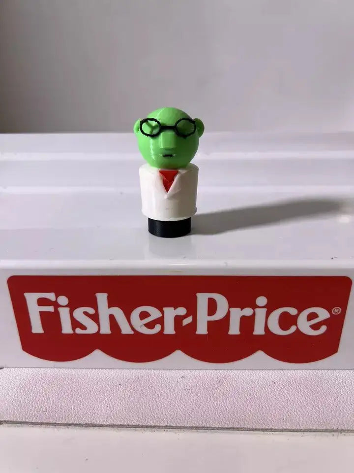 A custom 3D printed Little People-style "Muppet Dr. Bunsen Honeydew" figure stands on a Fisher-Price toy.