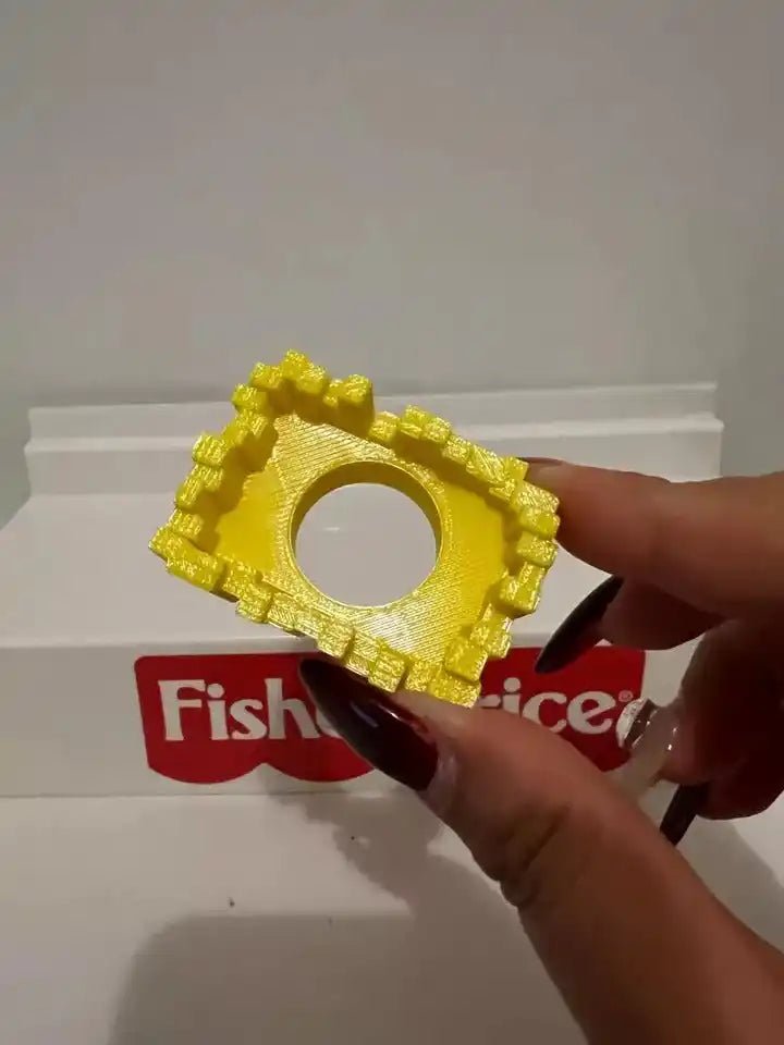Yellow textured fries basket piece held in hand for Fisher-Price fry cart