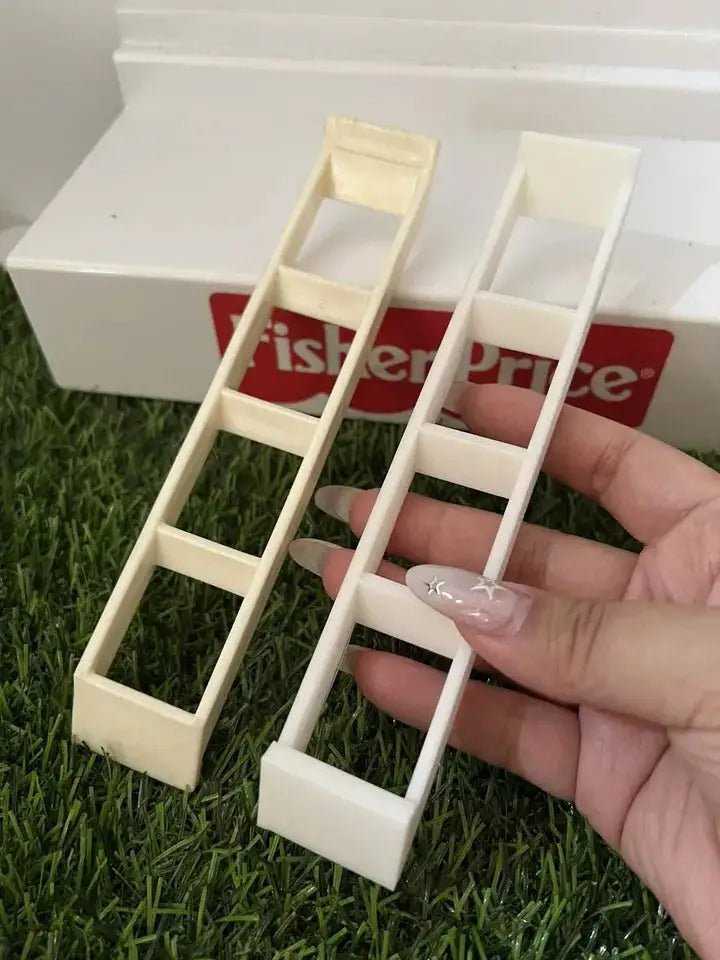 Close-up of two white plastic dollhouse ladders with open rungs and side rails