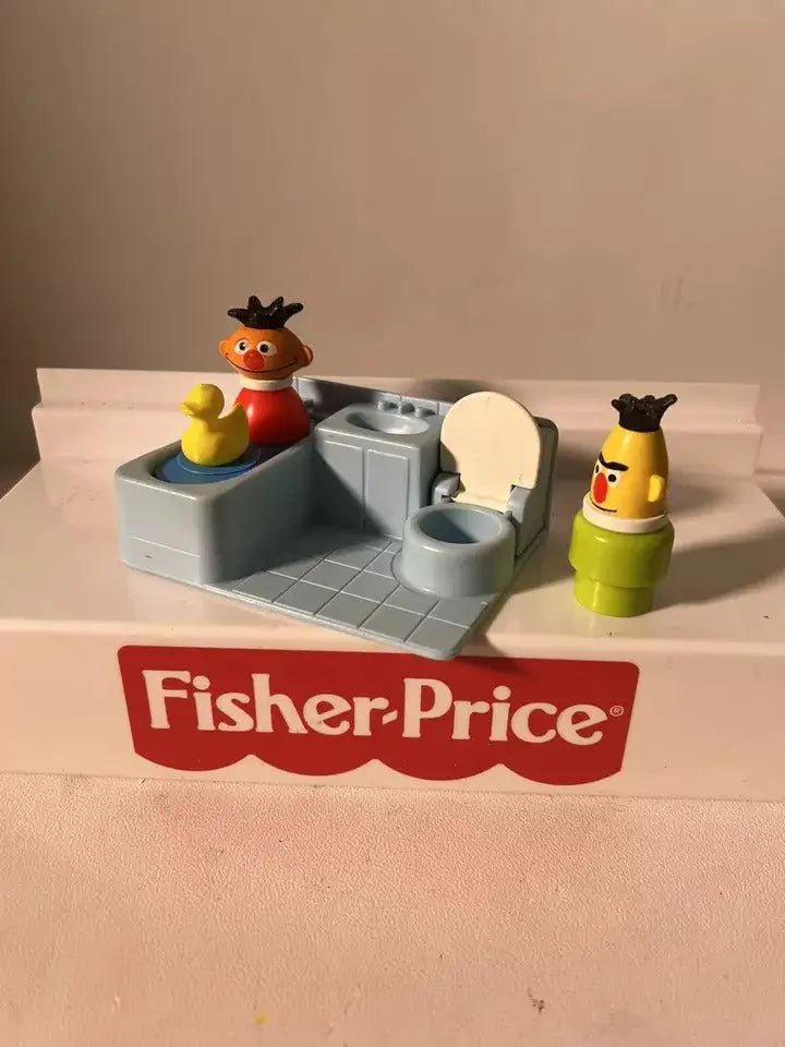 Gray water play insert with yellow rubber duck toy and Fisher-Price figures