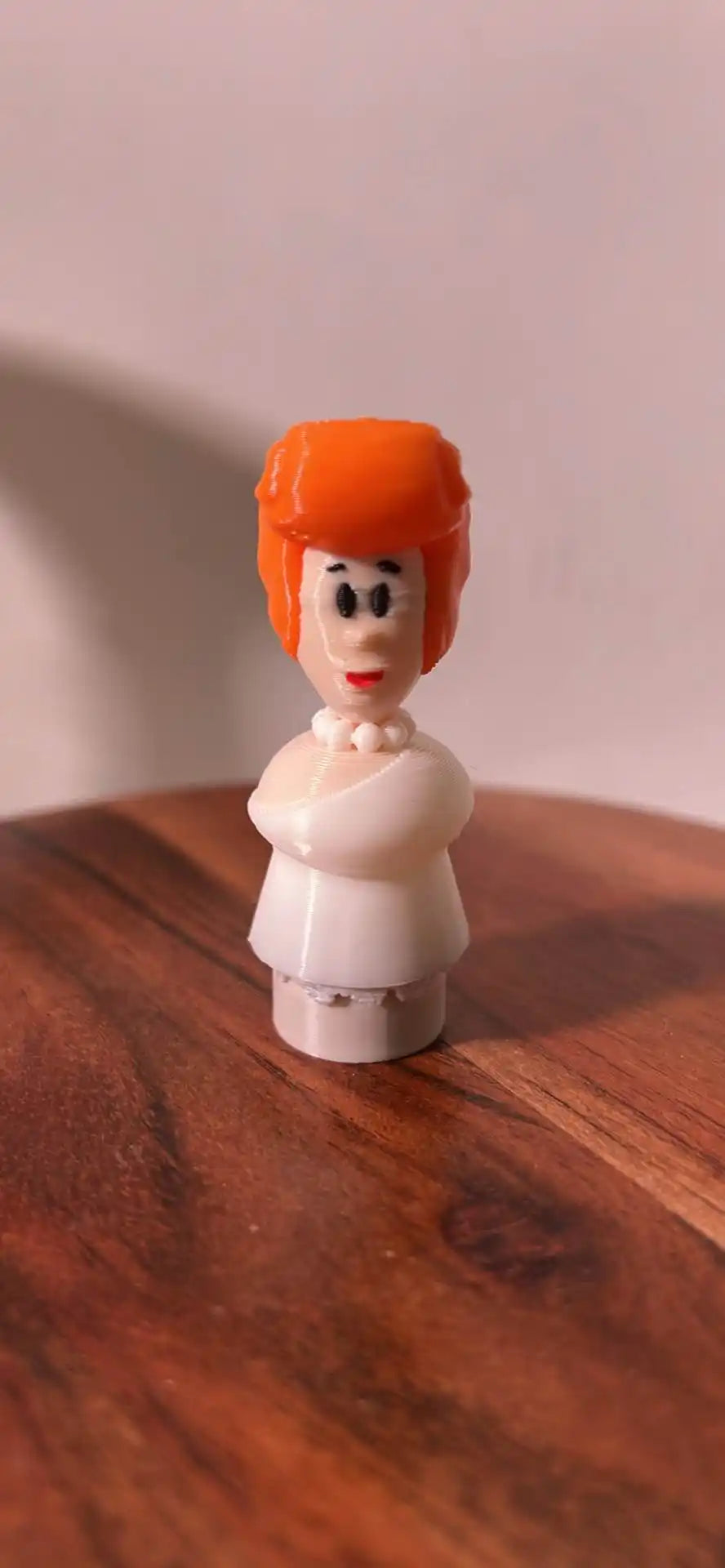 A custom 3D printed Flintstones Wilma Little People figure stands on a wooden surface with a light background.