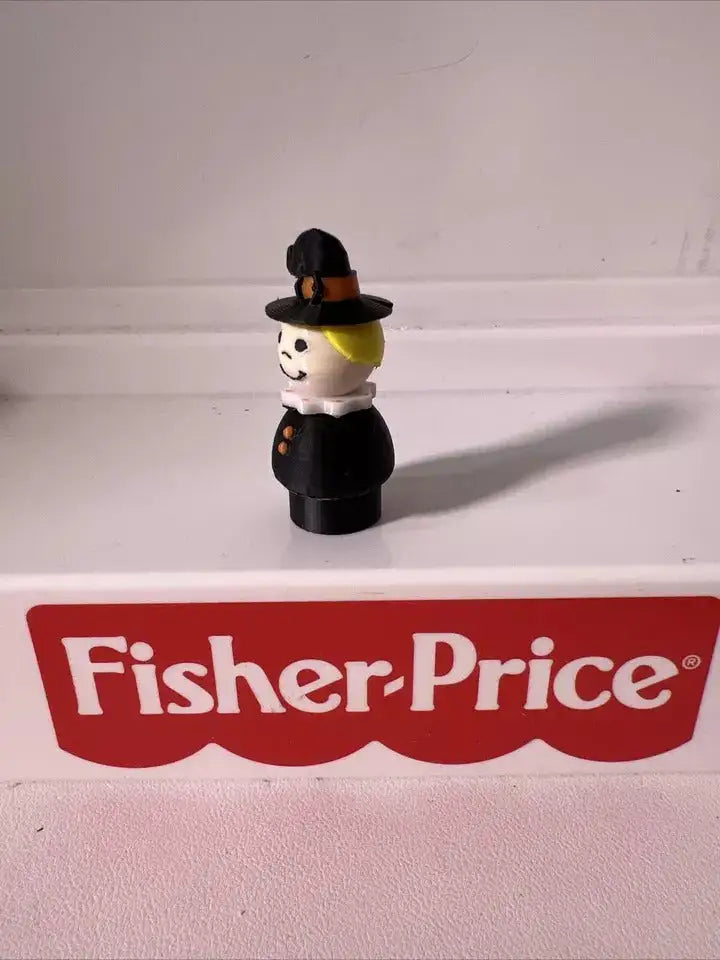 Halloween witch figurine, side view: black hat and dress with white face and yellow collar.