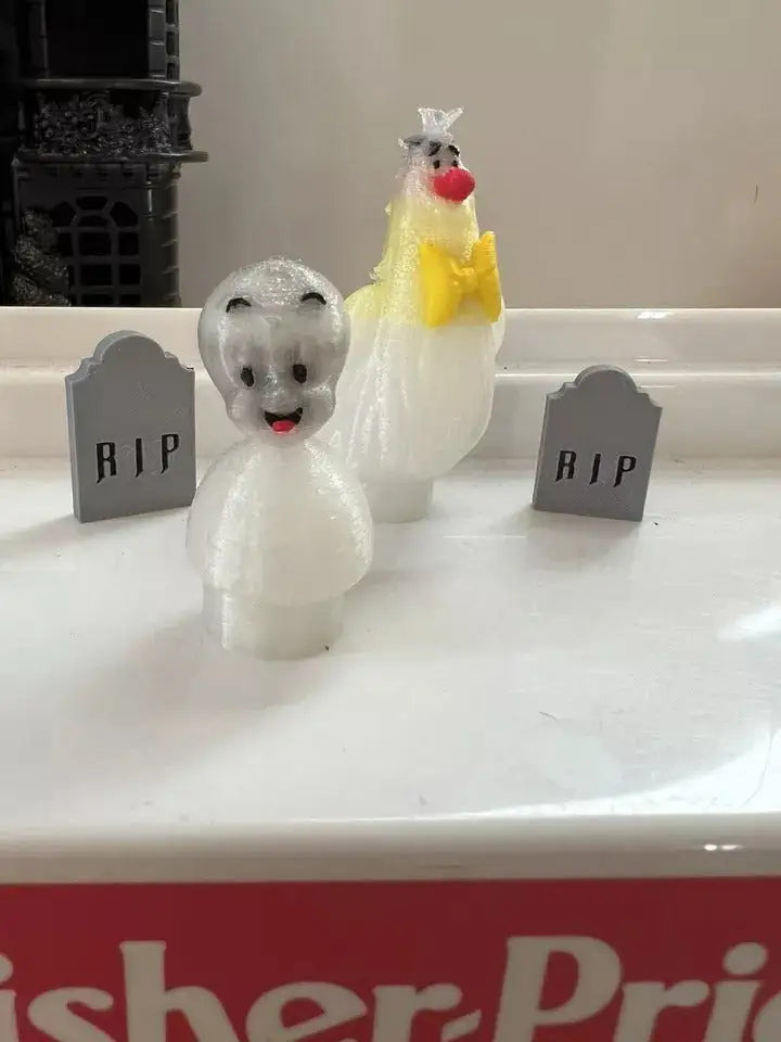 Casper figurines set: white ghost and yellow ghost with black eyes and red mouth.