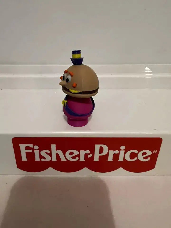 Cheese-headed mayor toy figurine, side view, brown head, magenta outfit, blue hat